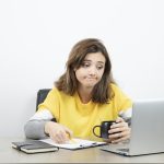 photo female office worker sitting desk with laptop clipboard high quality photo